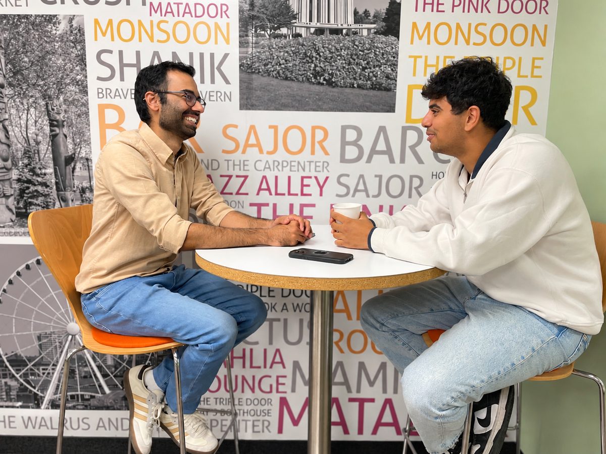 Two teammates talking at a small café table