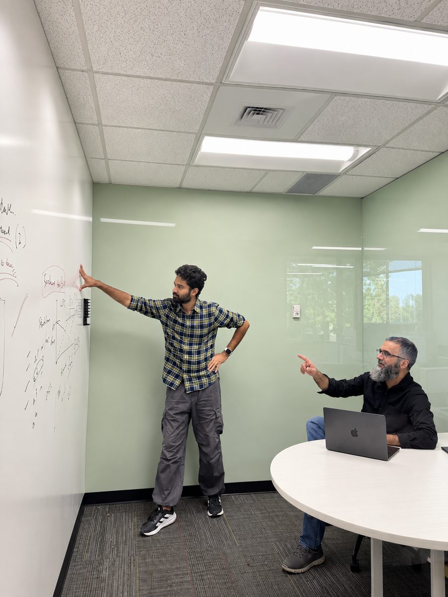Two teammates at a whiteboard in a small meeting room